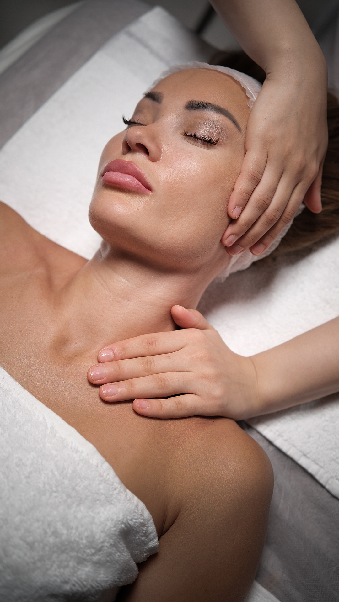 Woman relaxing during a professional facial treatment, highlighting luxury skincare services at a salon.